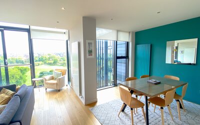 Living room/dining - Stylish open-plan livingroom/dining room featuring floor to ceiling windows with amazing views over the park and city at Edinburgh self catering apartment.