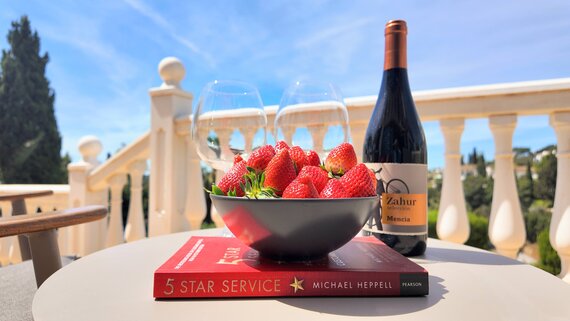 Five Star Service - Image is of a bottle of regional red wine, a bowl of strawberries and a book on 5 start service. (© Goto Property Management)