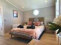 Master bedroom with double bed in holiday lodge near Chichester