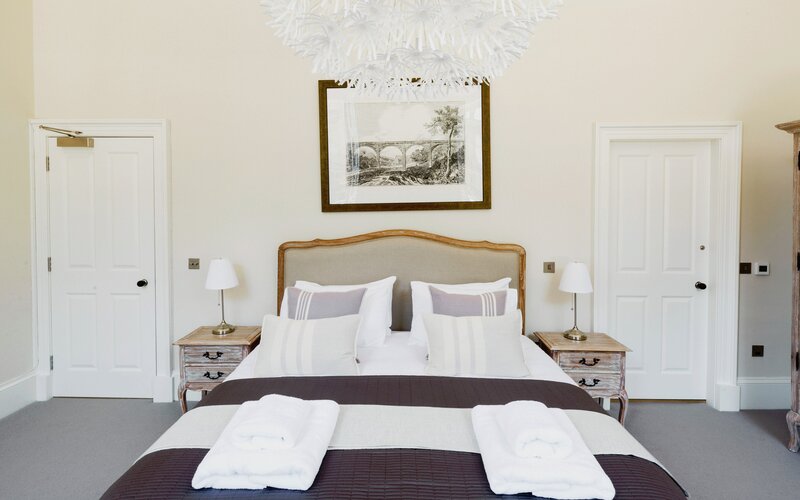 Bedroom in a Family Friendly Apartment - Master bedroom featuring an en-suite bathroom and a soothing beige palette with elegant wooden accents (© The Edinburgh Address) Bedroom in a Family Friendly Apartment - Master bedroom featuring an en-suite bathroom and a soothing beige palette with elegant wooden accents (© The Edinburgh Address)