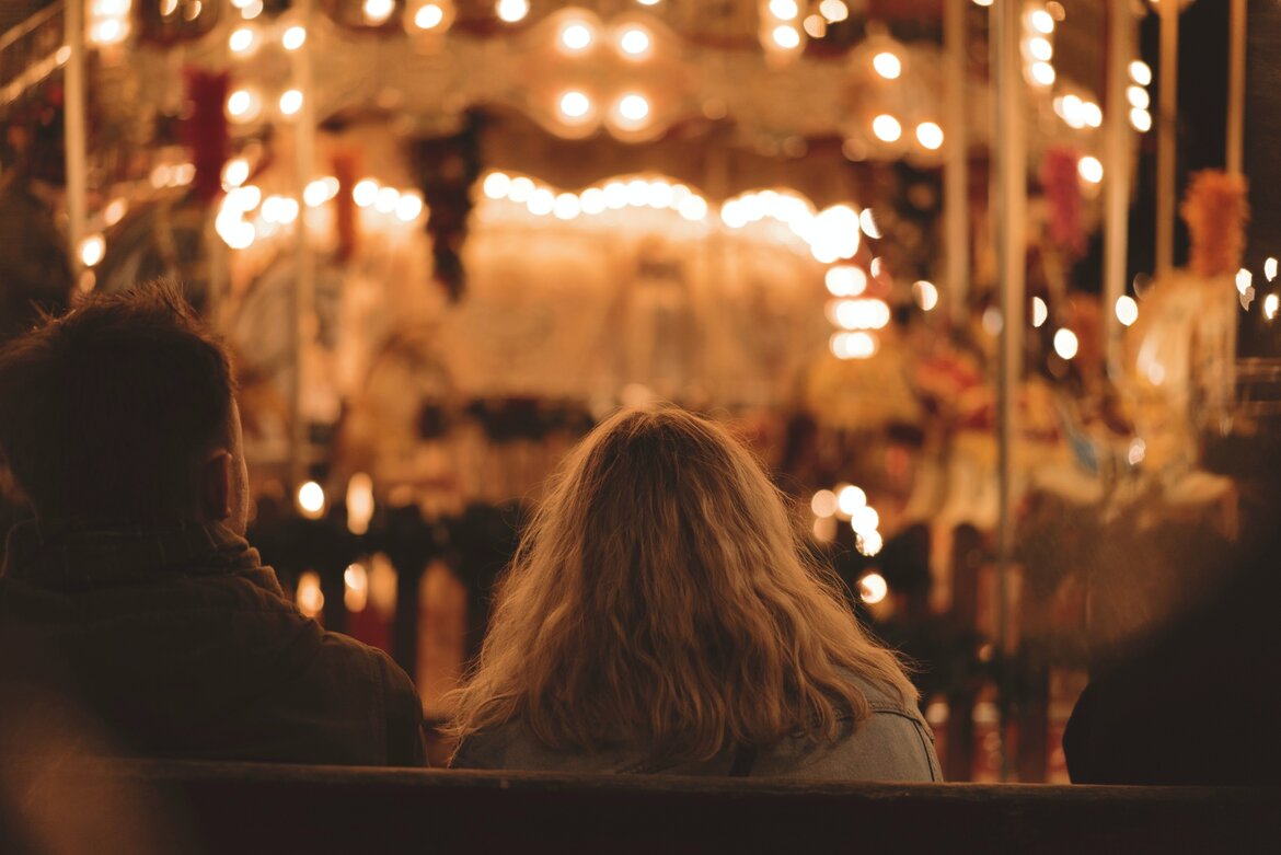 Romantic Christmas breaks in Edinburgh - A view over the shoulders of a man and woman, looking at twinkling lights in the darkness. (© Ross Sneddon)