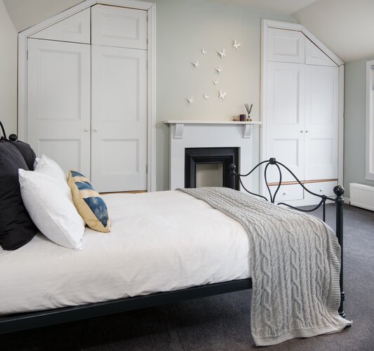 Spacious Bedroom for University Graduates - Elegant bedroom featuring comfortable, modern elements and ample natural light