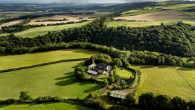 Aerial view of Pitmeadow Farm - View showing the farm surrounded by fields and beautiful countryside.