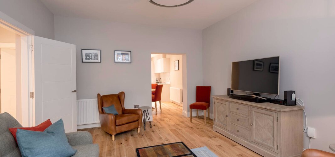 Cosy Lounge with Grey, Brown and Red Colour Touches - Stylish lounge area with a comfortable sofa and armchairs