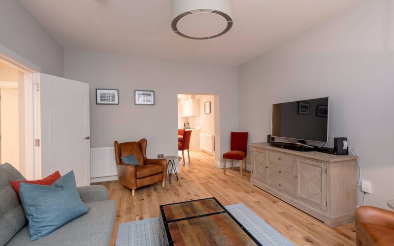Cosy Lounge with Grey, Brown and Red Colour Touches - Stylish lounge area with a comfortable sofa and armchairs