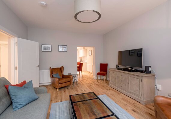 Cosy Lounge with Grey, Brown and Red Colour Touches - Stylish lounge area with a comfortable sofa and armchairs