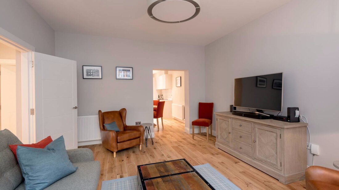 Cosy Lounge with Grey, Brown and Red Colour Touches - Stylish lounge area with a comfortable sofa and armchairs