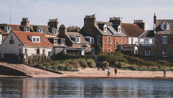 North Berwick coastal town - View over the beach from the water towards the town of traditional brick buildings. (© Mieke Campbell @ Unsplash)