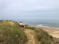 Man on bench seat on the top of the dune