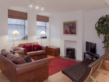 Open Plan Living Area - Warm and cosy with designer touches such as the Barcelona chairs! (© The Edinburgh Address)