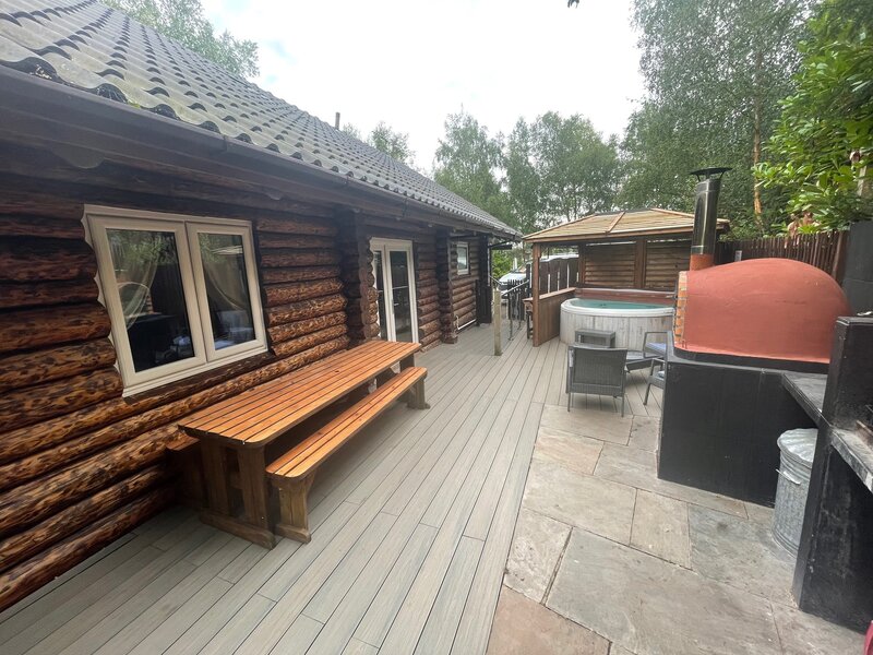 Woodpecker log cabin with fishing, pizza oven, hot tub situated