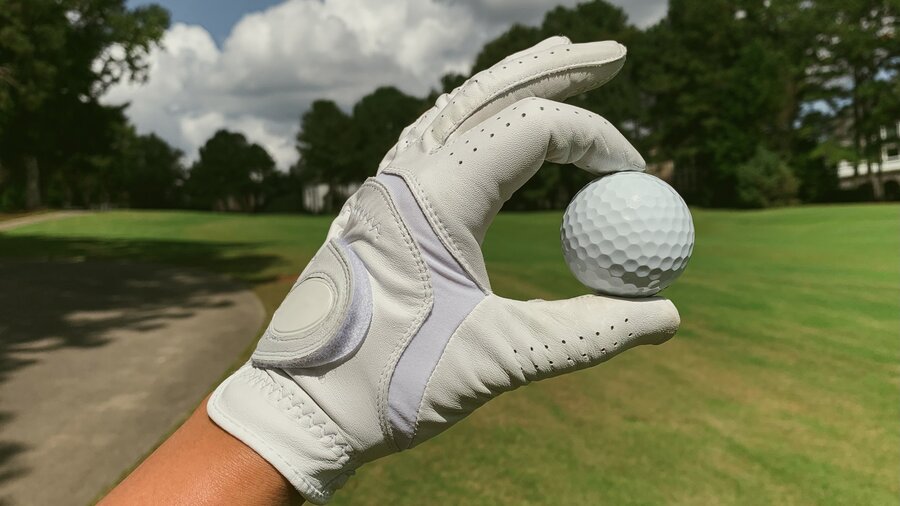 Golf in East Lothian - Gloved hand holding a golf ball on a golf course (© mk-s on Unsplash)