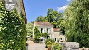 Moulin de la Fosse Gîtes - Gîtes in France surrounded by lush green trees.
