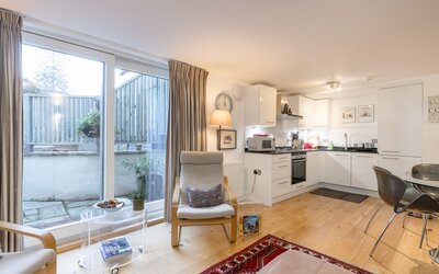 seating area with sliding doors to the private garden - Holiday home with open plan ground floor offers a cosy sitting/dining area with sliding doors opening into the garden