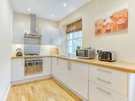 Gloucester Lane 11 - Contemporary, gleaming white kitchen within New Town Edinburgh holiday apartment.