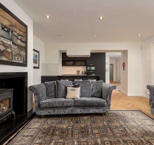Living Room/Kitchen - Open plan contemporary kitchen and living space featuring a log stove and fireplace in Edinburgh. holiday home.