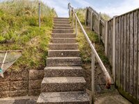 Steps with handrail leading to top of dune and beach