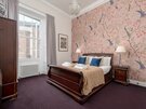 Spacious Bedroom for families attending Graduation - A king sized bed adorned with Scottish-inspired tones, complemented by fresh towels and soft, comfortable sheets