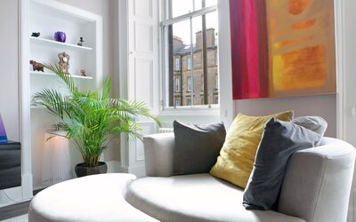 Living room - Details of cosy love seat with foot stool in living room