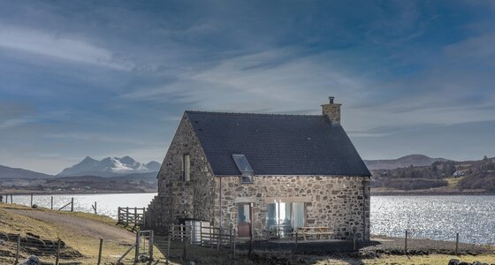 Exterior View of a Holiday Let in  Scotland - A stunning stone cottage featuring outdoor seating, with dramatic mountain and loch views