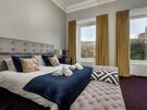 Bright and Airy Primary Bedroom with En-Suite Bathroom - This beautifully appointed primary bedroom offers refined comfort with high ceilings, natural light, and an en-suite bathroom complete with marble finishes and shower.
