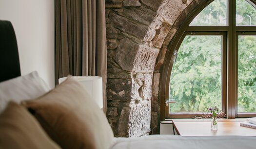 WILLSCOTT-MONZIE-OLDCHURCHTOWER1-10 - A bed next to a big arched window with stunning views.