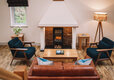 Leather couch and armchairs with coffee table in front of fireplace.