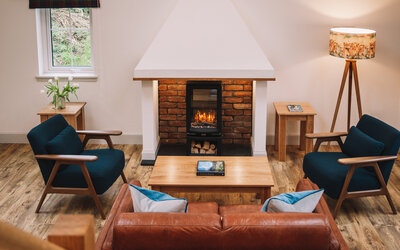 Relaxing after a day exploring hidden places in Skye. - Spacious sitting room for relaxing in front of the fire. The traditional fireplace and chimney reflect vernacular West Highland architecture giving this luxurious cottage an authentic vibe.