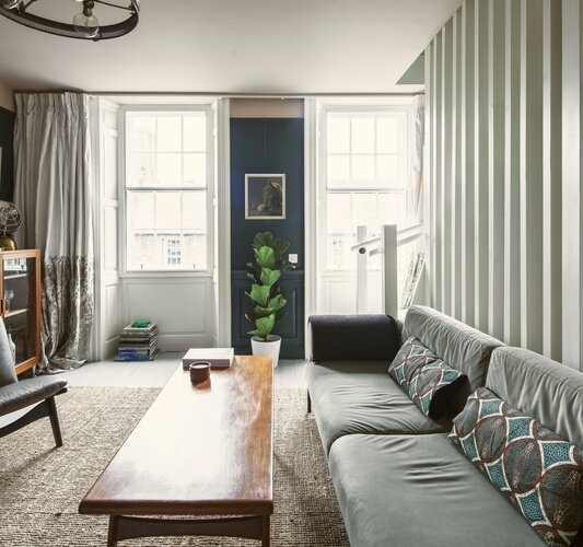 Bright Living Room Area in Scotland - Cosy lounge featuring a large dark-coloured sofa, a rustic table and stunning views