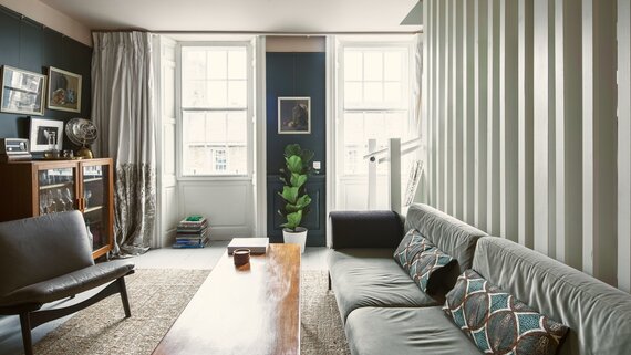 Bright Living Room Area in Scotland - Cosy lounge featuring a large dark-coloured sofa, a rustic table and stunning views