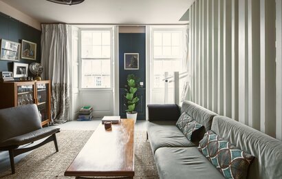 Bright Living Room Area in Scotland - Cosy lounge featuring a large dark-coloured sofa, a rustic table and stunning views