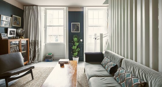 Bright Living Room Area in Scotland - Cosy lounge featuring a large dark-coloured sofa, a rustic table and stunning views