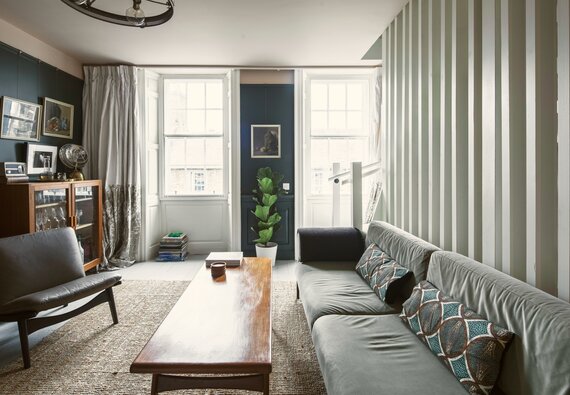 Bright Living Room Area in Scotland - Cosy lounge featuring a large dark-coloured sofa, a rustic table and stunning views