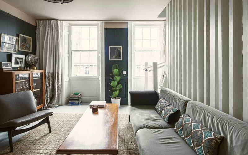 Bright Living Room Area in Scotland - Cosy lounge featuring a large dark-coloured sofa, a rustic table and stunning views