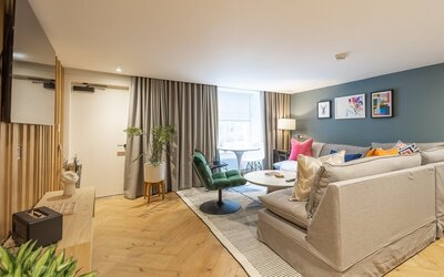 36a37724-1ad4-49a8-a9ab-af1100dba33f - An inviting living room designed with modern travellers in mind. It features comfortable seating and stylish furnishings, creating a relaxing atmosphere in the heart of the city.