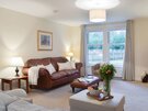 Mulberry Lodge/Carberry Tower - Leather sofa in living area, with views out to the private garden in East Lothian holiday home.