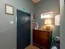 Entrance Hallway in a Self-Catered Apartment - The entrance features a welcoming lamp, Edinburgh guides, a wall-mounted fire extinguisher and an anti-bacterial dispenser