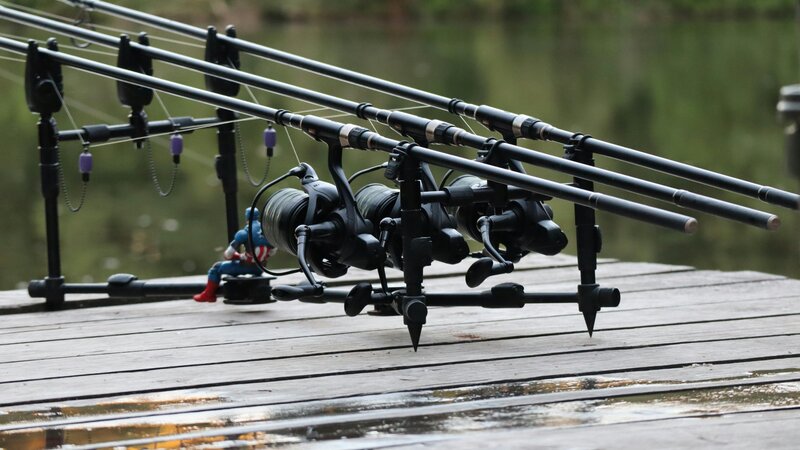 Fishing jetty and lake view - Fishing rods set up on a pier by a tranquil river, Ideal for angling enthusiasts. (© 2022 Michael Waddle)
