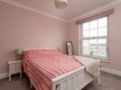 Double Bedroom with En-suite - The inviting double bedroom features soft pink décor, a comfortable double bed, en-suite shower room and large north-facing window, providing an ideal space for couples, friends or Festival visitors.