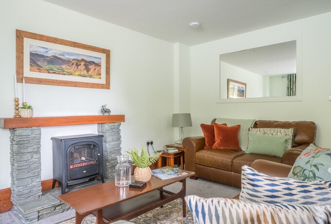 Lounge/dining nook - Spacious lounge area with 2 leather sofas, plump cushions, throws, coffee table, electric stove and smart TV.  A dining nook to one side with table and 4 chairs.