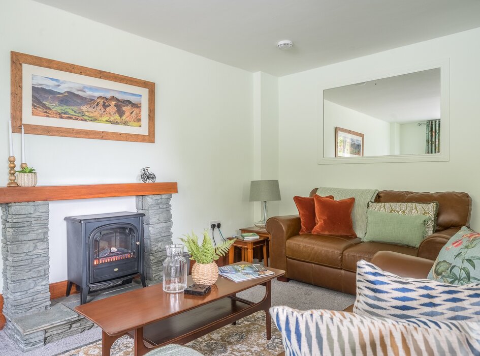 Lounge/dining nook - Spacious lounge area with 2 leather sofas, plump cushions, throws, coffee table, electric stove and smart TV.  A dining nook to one side with table and 4 chairs.