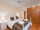 The Park (Holyrood Road) 3 - Double bedroom with tartan throw and cushions and large built-in wardrobe