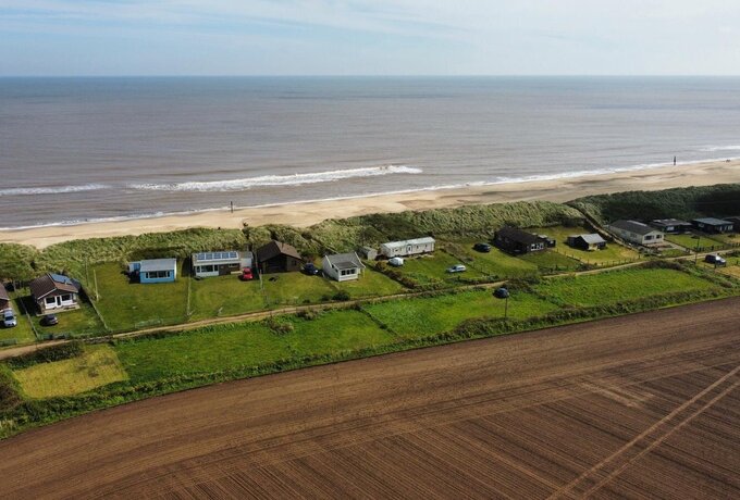 An aerial view of the Norfolk Coast - An aerial view taken by a drone of the beach and beachside cottages on the North Norfolk coast at Eccles on Sea.