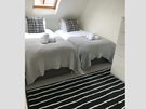 ArdmillanTerrace_006 - Twin bedroom with black and white decorative cushions, stripy rug and skylight window