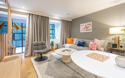 ede0f07b-0a2b-40ac-ab3d-af1100d93c26 - An inviting living room designed with modern travellers in mind. It features comfortable seating and stylish furnishings, creating a relaxing atmosphere in the heart of the city.