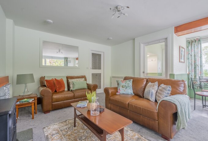 Lounge - Spacious lounge area with 2 leather sofas, plump cushions, throws, coffee table, electric stove and smart TV.  A dining nook to one side with table and 4 chairs.