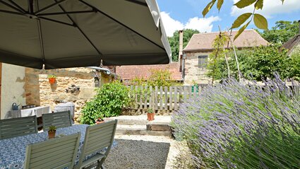 French holiday apartment with Private Garden - Blue lavender in the private enclosed garden with sun umbrella, garden table and chairs. (© Voila Villas France)