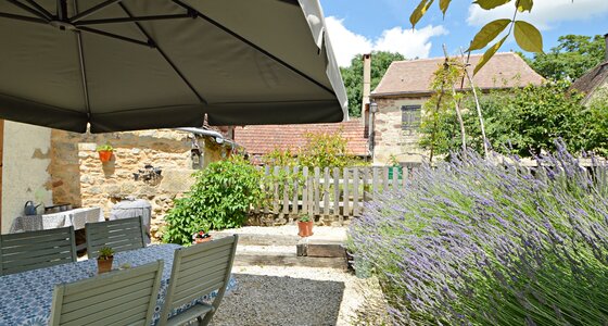 French holiday apartment with Private Garden - Blue lavender in the private enclosed garden with sun umbrella, garden table and chairs. (© Voila Villas France)
