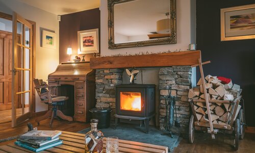 The Shambles - Luxury Lodge in Aviemore with hot tub and BBQ hut - Cosy living room with wood burning stove and antique furniture at The Shambles, Aviemore