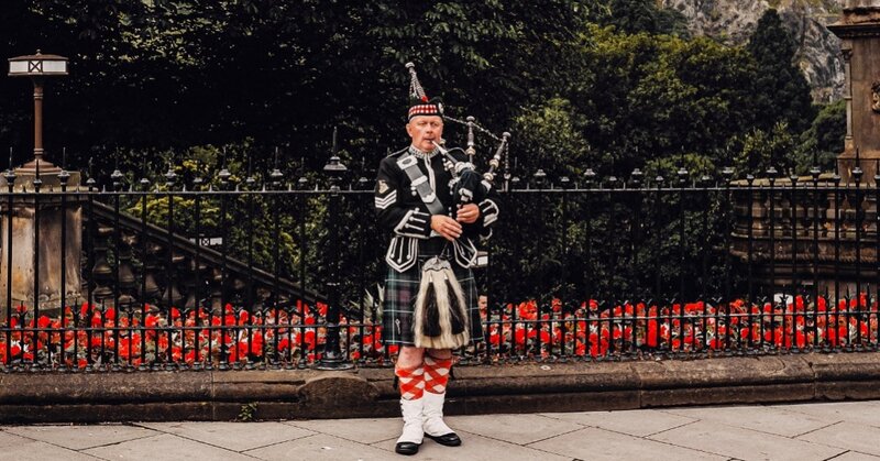 Bagpipes in Princes St, Edinburgh - Piper in a kilt playing bagpipes in front of Edinburgh castle. (© Samuel Regan-Asante on Unsplash)